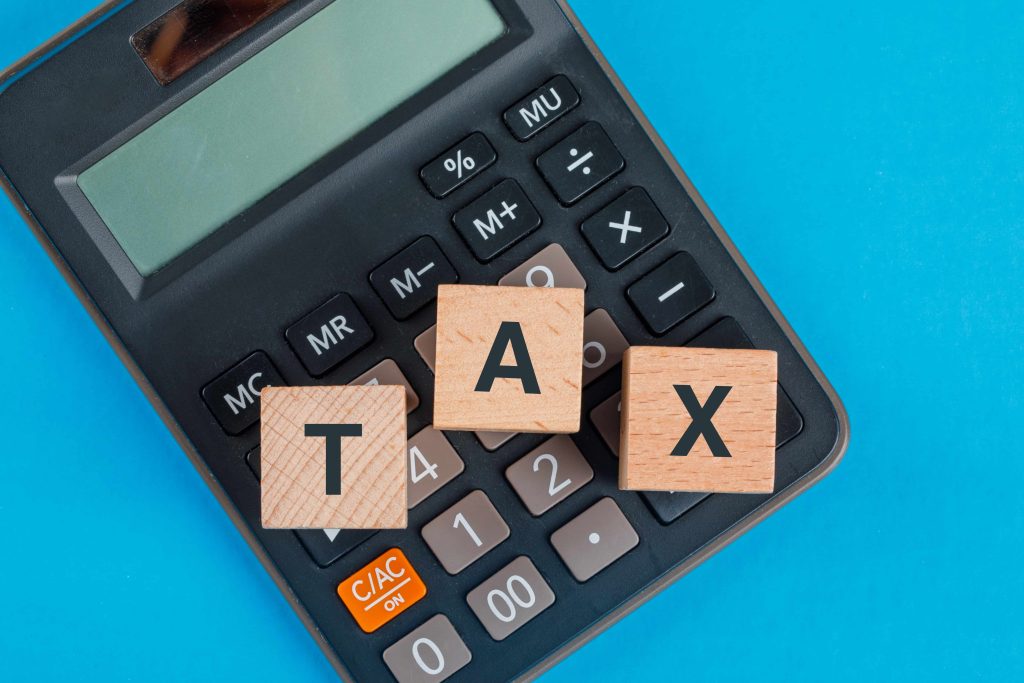 Tax planning concept with wooden cubes calculator blue table