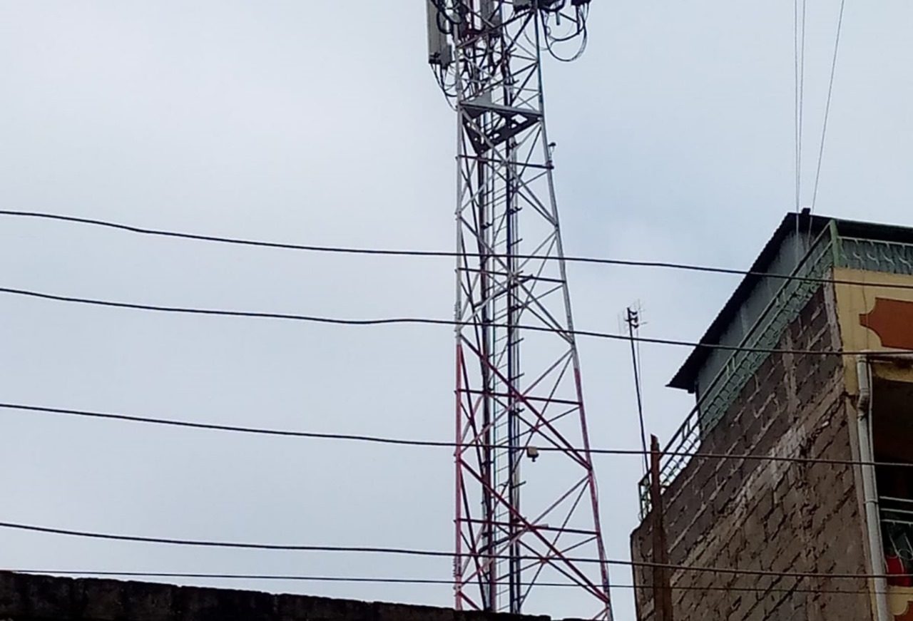 Telcomm mast set up with a building in the background